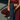 Person in maroon athletic wear holding a blue yoga mat on a tiled floor