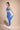 Woman in blue athletic wear stretching on a beige background