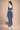 Woman wearing a blue athletic outfit standing against a beige background