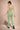 Woman wearing a green athletic outfit on a beige background