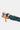 Person lying on a cork yoga bolster on a white background
