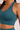 Woman in a teal sports bra and matching teal leggings