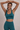 Woman in a teal sports bra and matching teal leggings