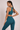 Woman in a teal sports bra and matching teal leggings
