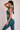 Woman wearing a teal athletic outfit on a plain background