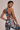 Woman wearing a floral sports bra and leggings set on a beige background
