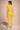 Person wearing a yellow athletic outfit on a beige background