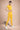 Woman wearing a yellow athletic outfit on a beige background