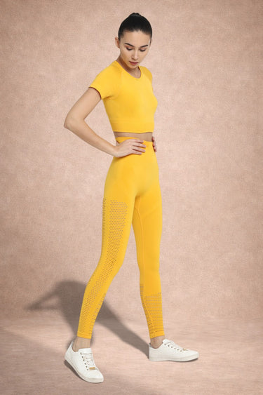 Woman wearing a yellow athletic outfit on a beige background