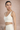 Woman wearing a white Shakti Warrior sports bra and white leggings