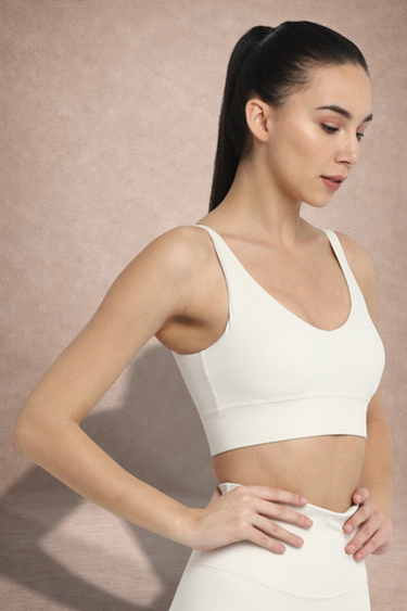 Woman wearing a white Shakti Warrior sports bra and white leggings