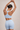 Woman wearing a ribbed light blue sports bra and matching shorts set