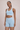 Woman wearing a high support ribbed light blue sports bra and matching shorts set