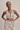 Woman wearing a patterned sports bra and leggings on a beige background
