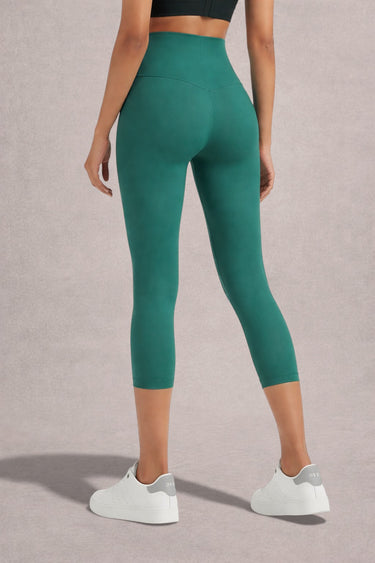 Person wearing Shakti Warrior High-waist AumLux Capri Leggings in a teal colour