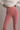Person wearing pink leggings and a white top against a neutral background