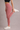 Person wearing pink leggings and white sneakers on a plain background