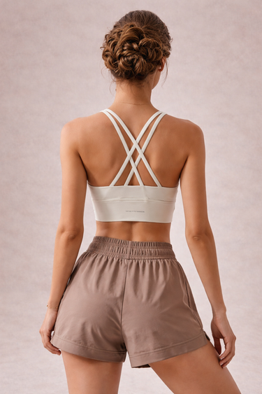 A woman wearing a white sports bra which has high support