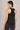 Woman wearing a black tank top with mesh panels on a neutral background