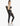 Woman in black athletic wear holding a yoga mat