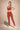Woman wearing Shakti Warrior IVY medium support strawberry red yoga set