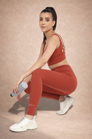 Woman wearing Shakti Warrior IVY medium support strawberry red yoga set