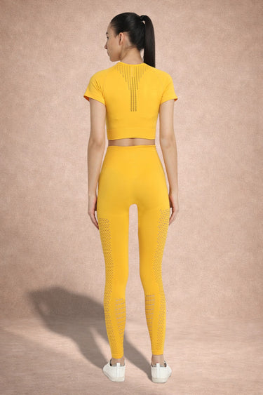 Person wearing a yellow athletic outfit on a beige background