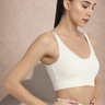 Woman wearing a white Shakti Warrior sports bra and white leggings