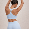 Woman wearing a ribbed light blue sports bra and matching shorts set