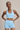 Woman wearing a high support ribbed light blue sports bra and matching shorts set