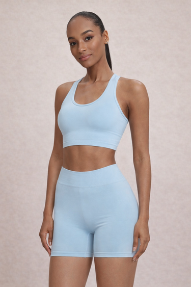 Woman wearing a high support ribbed light blue sports bra and matching shorts set