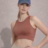 A woman wearing a sports bra in a solid color with mesh fabric panels on the back, paired with high-waisted leggings.