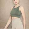 Woman wearing a green Shakti Warrior sports bra and beige leggings