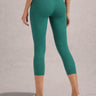 Person wearing Shakti Warrior High-waist AumLux Capri Leggings in a teal colour
