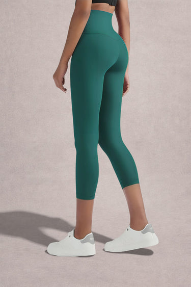 Person wearing Shakti Warrior High-waist AumLux Capri Leggings in a teal colour