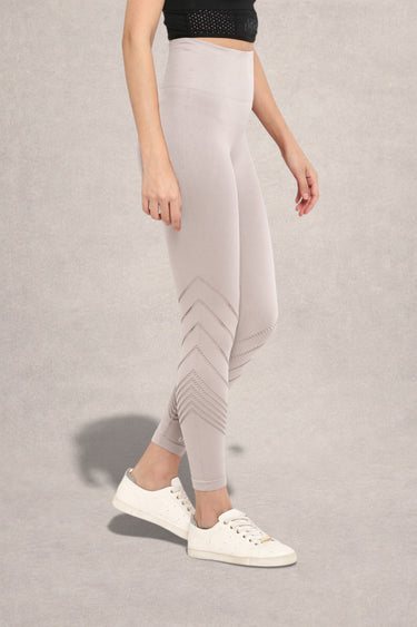 Light gray leggings with laser cut on a neutral background