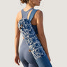 Woman holding a blue and white patterned yoga mat against a plain background