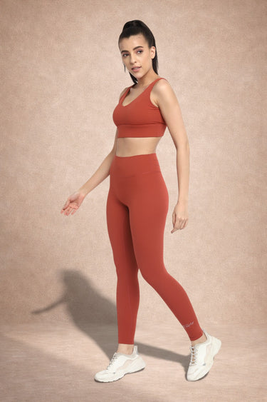 Woman wearing Shakti Warrior IVY medium support strawberry red yoga set